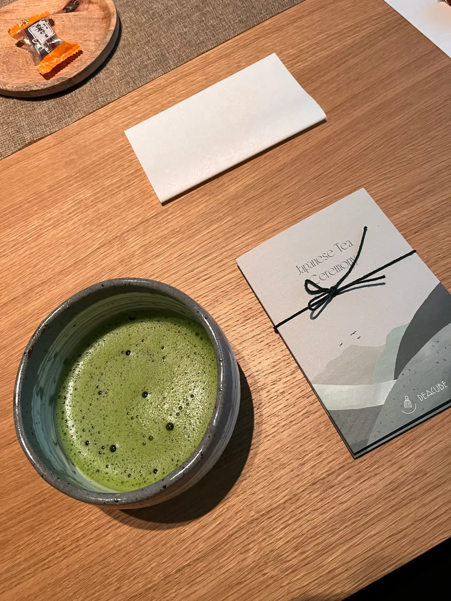 Kom matcha naast een kaartje met Japanse knoopversiering